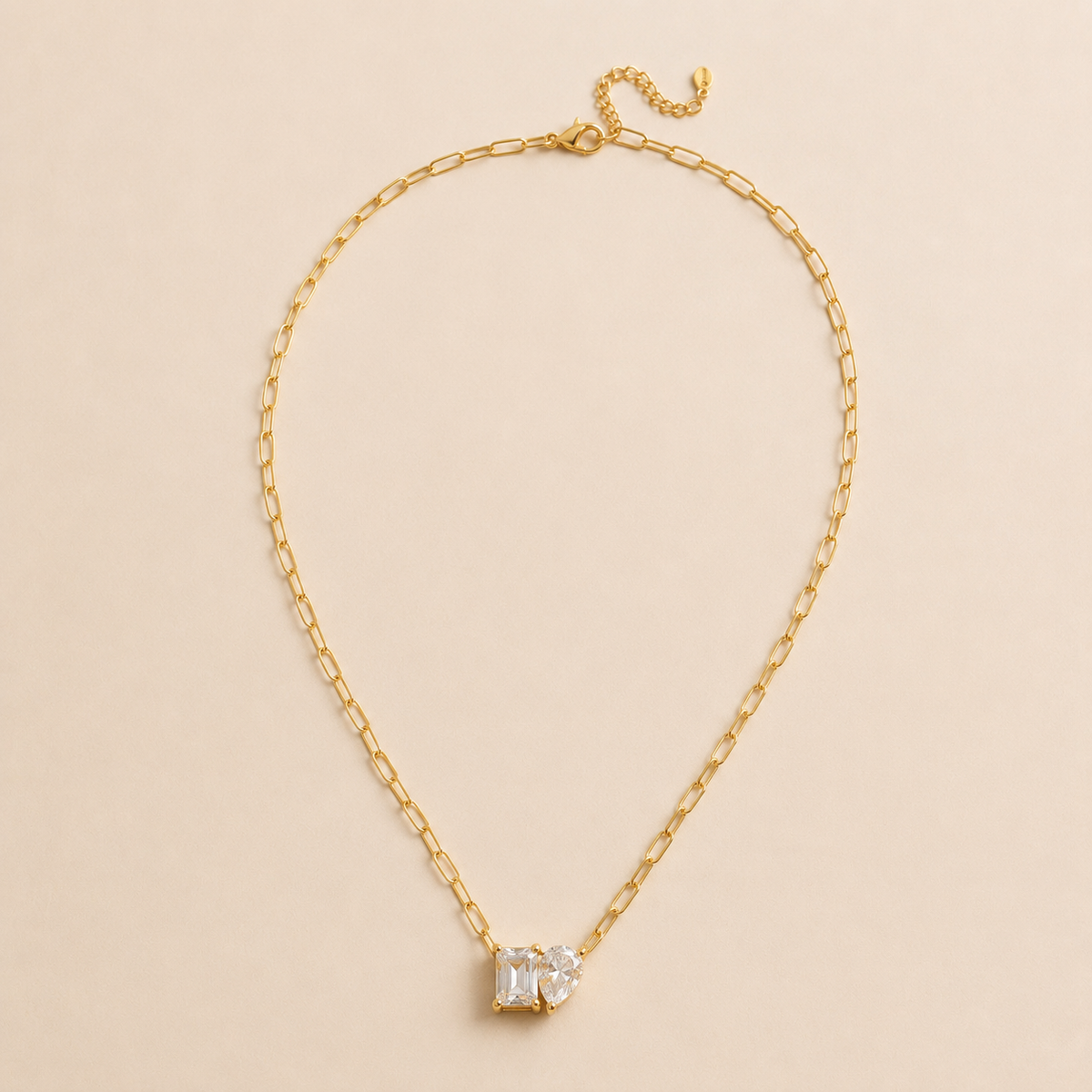 Necklace Shape gouden paperclip ketting met dubbele kristallen hanger op beige achtergrond